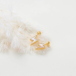 Detailed macro of gold lightning pendants with iridescent white shell inlay for DIY jewelry