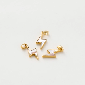 Macro shot of three lightning bolt pendants with gold plating and white shell inlay