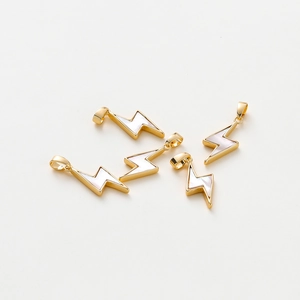 Macro detail of lightning bolt charms with real gold plating and shell inlay for DIY jewelry