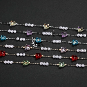 Macro detail of butterfly crystal and pearl chain showing 4mm pearls and 8mm colorful charms