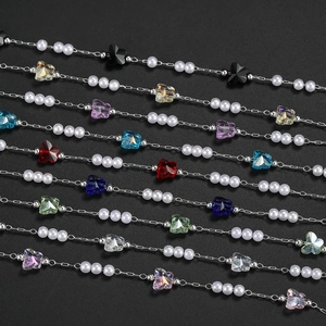 Detailed view of copper jewelry chains featuring butterfly crystals and pearls