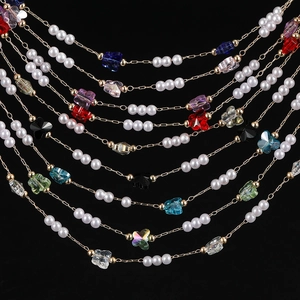 Detailed view of handmade gold chain with pearls and colorful crystal butterfly charms
