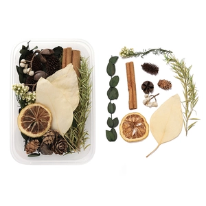 Detail of DIY set with dried pine cones, lemon slices, cinnamon sticks and green leaves