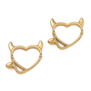 Dettaglio macro di ciondoli a cuore placcati oro 18K con corna e coda di diavolo per fai da te