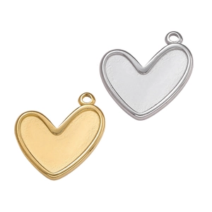 Vista macro di ciondoli a cuore in acciaio inossidabile oro e argento per gioielli fai-da-te