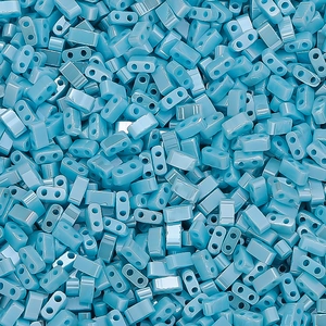 Macro view of light blue square glass seed beads with dual holes for DIY jewelry making