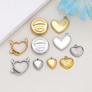 Macro di ciondoli a cuore in oro 18K e argento con incisioni Love su base in tessuto morbido
