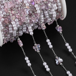 Detail of DIY butterfly bead chain with faux pearls and pink butterflies on white spool