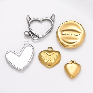 Dettaglio di ciondoli a cuore placcati oro 18K con incisione Love e farfalla smaltata