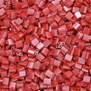 Close-up of glossy red rectangular two-hole glass beads for DIY jewelry and bracelets