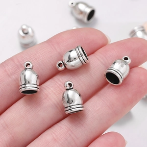 Macro view of silver alloy bell caps with hanging loops for DIY jewelry making