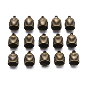 Macro detail of 15 bronze bell-shaped tassel end caps for DIY jewelry and crafts