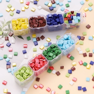 Square glass two-hole spacer beads in assorted solid colors with a clear storage case