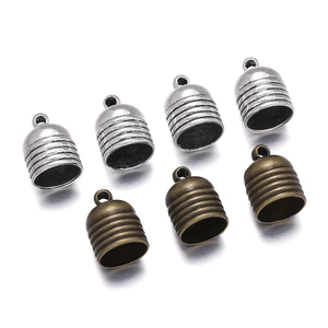 Detailed view of silver and bronze bell-shaped alloy cord end caps with grooved design