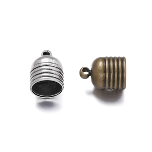 Detail view of bell-shaped zinc alloy cord ends in silver and bronze for jewelry making