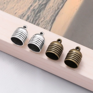 Detail of vintage zinc alloy tassel end caps for DIY jewelry making in silver and bronze