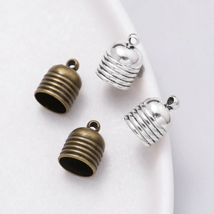 Macro detail of bell-shaped zinc alloy cord end caps with ribbed texture and loop rings