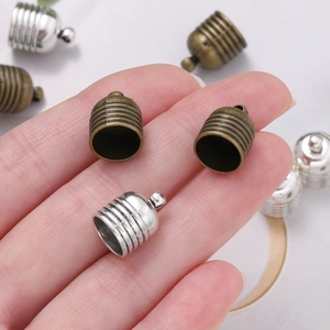 Macro view of vintage zinc alloy end caps with textured threading for tassel jewelry making