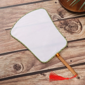 Detail of white blank silk fan with green patterned edge and decorative red tassel