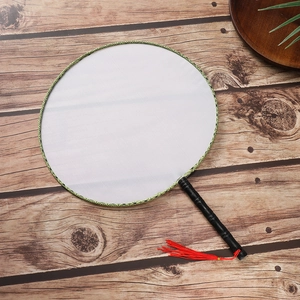 Detail of round blank fan with green trim, black bamboo handle and red silk tassel