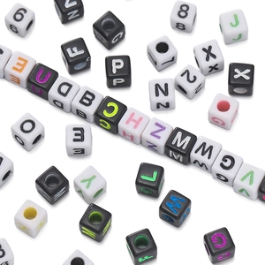 Macro-opname van vierkante acryl kralen met gekleurde letters voor DIY-sieraden maken