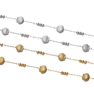 Detail of vacuum plated stainless steel shell chain with golden and silver bead accents