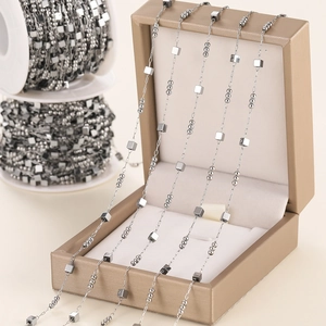Detail of silver stainless steel chain with cubes and beads for DIY jewelry making