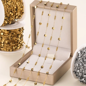 Macro detail of gold stainless steel geometric cube bead chains for DIY jewelry making