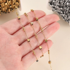 Detail of DIY gold stainless steel cube bead chain held in hand for jewelry making