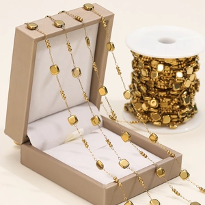 Macro view of gold-plated square beads and round spacer chain for DIY jewelry making