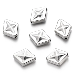 Primer plano de espaciadores de rombos plateados con patrones de estrellas para joyería