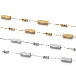 Detailed macro view of square link and bead chain in gold and silver stainless steel