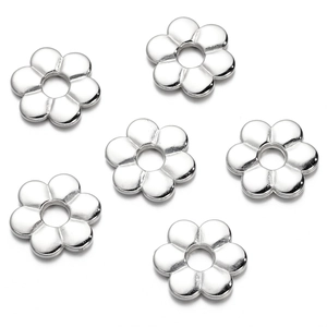 Detalle de cuentas espaciadoras plateadas en forma de flor de seis pétalos para bisutería