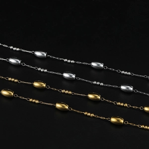 Detailed view of polished gold and silver oval bead chains on a black background