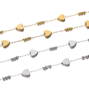 Detail of stainless steel gold and silver chains with heart charms and small beads