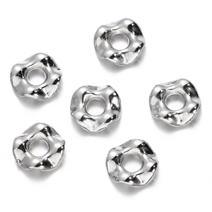Primer plano de cuentas espaciadoras plateadas onduladas para joyería DIY