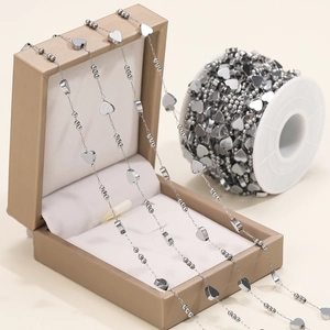 Macro detail of stainless steel heart and bead chain on a roll for jewelry making