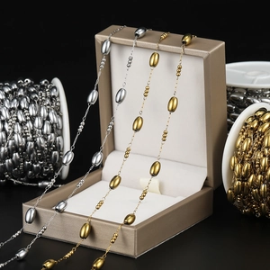 Detail of gold and silver stainless steel oval link chains with small beads for DIY jewelry