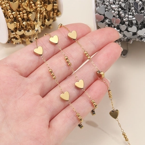 Detail of stainless steel heart chain with gold beads for DIY jewelry making