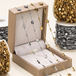 Detail of star-shaped stainless steel chain in gold and silver finishes on jewelry box