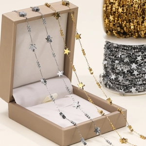 Detail of gold and silver star bead chains draped over a jewelry box for DIY projects
