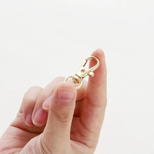 Close-up of a 14K gold-plated swivel lobster clasp held by hand for jewelry DIY