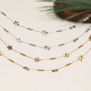 Close-up of delicate gold and silver chain with star charms and small round beads