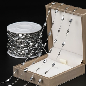 Close-up of silver steel beaded link chain for DIY jewelry making on a display box