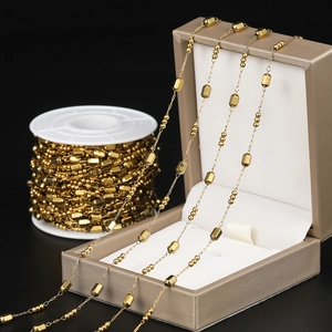 Close-up of golden stainless steel chain with geometric beads for DIY jewelry making