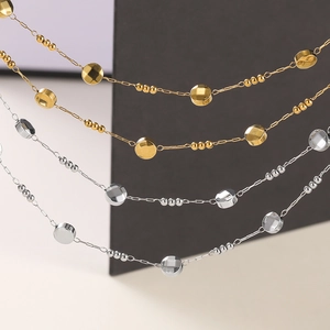 Detail of stainless steel oval chain and round beads in gold and silver finishes
