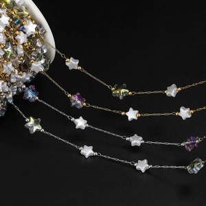 Macro detail of 18K gold and silver DIY jewelry chains with acrylic star beads