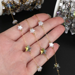 Detail of 18K gold plated stainless steel chain with pearlescent acrylic star beads