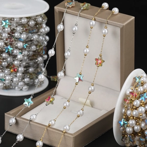 Detail of 18K gold stainless steel chain with white pearls and rainbow acrylic stars
