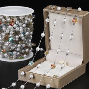 Detail of colorful acrylic star beads and white faux pearls on silver DIY jewelry chain